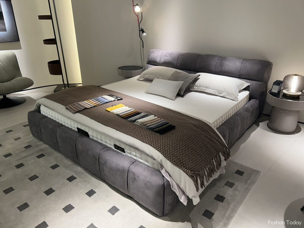 A dark grey double bed is placed in the center of the bedroom.