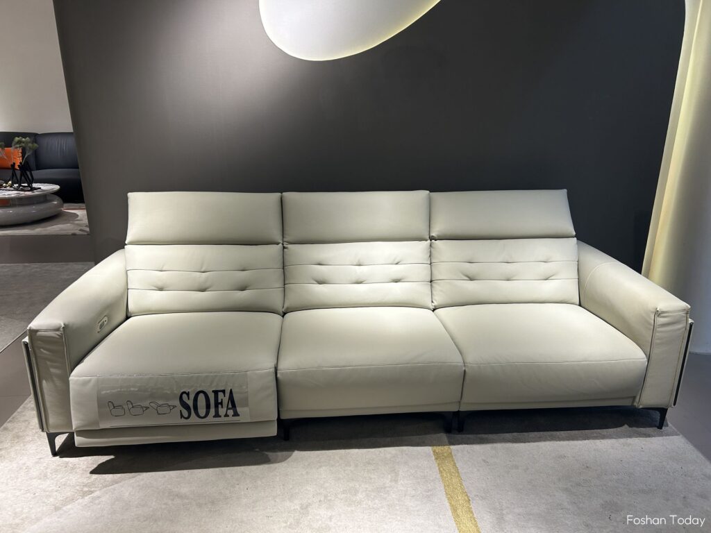 There is a gray multifunctional foldable sofa placed in the middle of the furniture exhibition hall